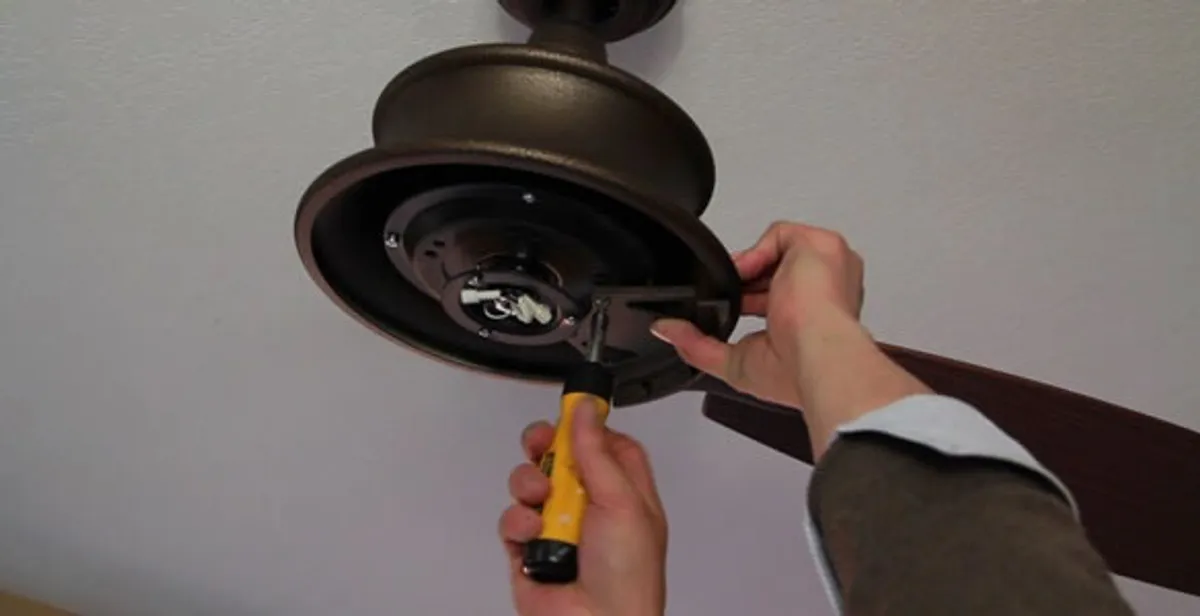 Electrician installing ceiling fan mounting bracket and fixture in Cherry Hill, NJ
