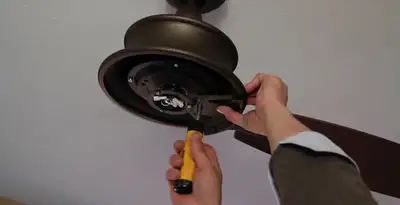 Electrician installing ceiling fan mounting bracket and fixture in Cherry Hill, NJ