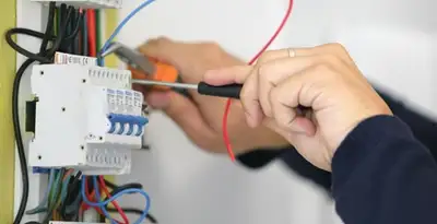 Electrician installing and adjusting circuit breakers in an electrical panel in Cherry Hill, NJ