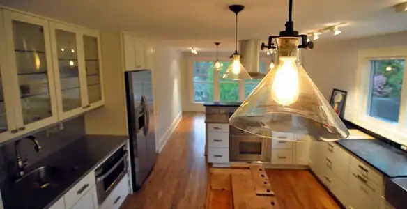 Residential electrician installing modern indoor light fixture in a home in Cherry Hill, NJ