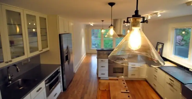 Residential electrician installing modern indoor light fixture in a home in Cherry Hill, NJ