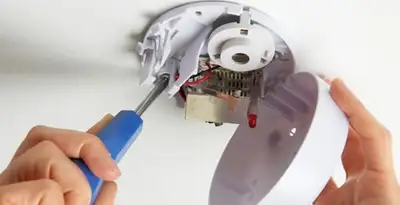 Certified technician wiring smoke detector during installation in Cherry Hill, NJ